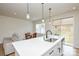 Open-concept kitchen with white cabinetry, an island with seating, and access to a dining area at 1028 Grays Mill Rd, Charlotte, NC 28215