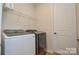 Convenient laundry room featuring a side-by-side washer and dryer and a wire shelf at 1028 Grays Mill Rd, Charlotte, NC 28215