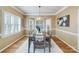 Dining room features a modern chandelier, large windows with shutters, and a rustic wooden table with seating for six at 10927 Thornhill Club Dr, Charlotte, NC 28277