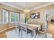 This light-filled dining room features a rustic table, designer chandelier and beautiful windows at 10927 Thornhill Club Dr, Charlotte, NC 28277