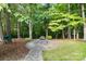 Outdoor fire pit area with stone pavers and lush landscaping, perfect for relaxing and entertaining at 10927 Thornhill Club Dr, Charlotte, NC 28277