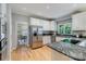 Modern kitchen with stainless steel refrigerator, granite countertops, white cabinetry, and hardwood floors at 10927 Thornhill Club Dr, Charlotte, NC 28277