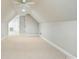 Bright and spacious attic area featuring carpeted floors, white walls, and a door leading to another room in the house at 116 Eve Ash Ln, Mooresville, NC 28115
