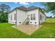 Exterior view of backyard featuring a white home and concrete patio surrounded by a lush, green lawn at 116 Eve Ash Ln, Mooresville, NC 28115