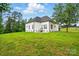 Rear exterior showcasing a white home, green lawn, and scenic backyard at 116 Eve Ash Ln, Mooresville, NC 28115