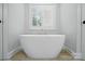 Bright bathroom features a stylish standalone tub with a large shuttered window and tile floors at 116 Eve Ash Ln, Mooresville, NC 28115