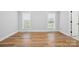 The bright bedroom features hardwood floors, neutral paint, and two windows providing natural light at 116 Eve Ash Ln, Mooresville, NC 28115