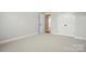 Neutral bedroom with carpeted floors, white walls, and a doorway to the hallway at 116 Eve Ash Ln, Mooresville, NC 28115