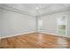 A bright and airy bedroom features hardwood floors, tray ceiling, and neutral paint at 116 Eve Ash Ln, Mooresville, NC 28115
