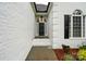 Inviting entryway with a black front door, brick facade, arched window, and landscaped garden beds at 116 Eve Ash Ln, Mooresville, NC 28115