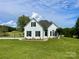 Desirable white brick home with black shutters on a large, grassy lawn and landscaped yard at 116 Eve Ash Ln, Mooresville, NC 28115