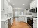 Open concept kitchen featuring an island and stainless steel appliances flows into the dining area at 116 Eve Ash Ln, Mooresville, NC 28115