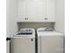 A well-lit laundry room features white cabinetry and modern front load washer and dryer at 116 Eve Ash Ln, Mooresville, NC 28115