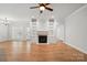 Open-concept living room with a fireplace, built-in shelving, hardwood floors, and plenty of natural light at 116 Eve Ash Ln, Mooresville, NC 28115