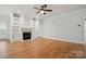 Spacious living room with a fireplace, built-in shelves, hardwood flooring, and ceiling fan at 116 Eve Ash Ln, Mooresville, NC 28115