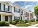 Attractive townhouses showcasing varied facades, green shutters, and manicured landscaping along a sidewalk at 12328 Jessica Pl, Charlotte, NC 28269