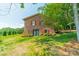 The brick home features a well manicured lawn, landscaping, and mature trees at 12705 Caldwell Rd, Charlotte, NC 28213