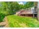 Expansive backyard featuring a wooden deck, lush green lawn, and mature trees at 12705 Caldwell Rd, Charlotte, NC 28213