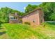 Backyard view of a brick home with a well-maintained lawn at 12705 Caldwell Rd, Charlotte, NC 28213