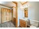 A bathroom with modern wood-look floors, a wood vanity, decorative lighting, and a toilet at 12705 Caldwell Rd, Charlotte, NC 28213