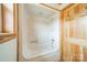 A bathtub and shower combination with a white surround, stainless steel fixtures and natural wood door at 12705 Caldwell Rd, Charlotte, NC 28213