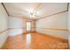 Empty bedroom with ceiling fan, wood floors, and a window at 12705 Caldwell Rd, Charlotte, NC 28213