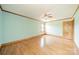 An empty bedroom with blue walls, wood trim, a ceiling fan, wood floors and one doorway at 12705 Caldwell Rd, Charlotte, NC 28213