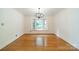 Elegant dining room featuring hardwood floors, white walls, and a bay window with scenic views at 12705 Caldwell Rd, Charlotte, NC 28213