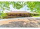 Charming single-story brick home featuring a covered porch and mature trees at 12705 Caldwell Rd, Charlotte, NC 28213