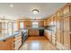 Open kitchen boasts wooden cabinetry, granite counters, stainless appliances, and hardwood floors at 12705 Caldwell Rd, Charlotte, NC 28213