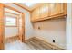 A laundry room with gray wood-look floors, built-in cabinets, and utility connections at 12705 Caldwell Rd, Charlotte, NC 28213