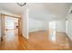 Spacious living room with hardwood floors, white walls, and a doorway to another room at 12705 Caldwell Rd, Charlotte, NC 28213