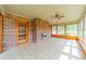 Enclosed sunroom with brick accent wall, tile floor, and multiple windows at 12705 Caldwell Rd, Charlotte, NC 28213