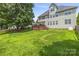 A large green backyard with a deck and mature trees, perfect for outdoor enjoyment at 128 Sugar Thyme Ln, Mooresville, NC 28115