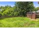 Lush backyard view, featuring a wooden fence, manicured lawn, and mature trees at 128 Sugar Thyme Ln, Mooresville, NC 28115