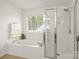 Bright bathroom with a separate tub and shower, and a window that looks to the outdoors at 128 Sugar Thyme Ln, Mooresville, NC 28115