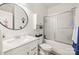 Bathroom featuring a white vanity, round mirror, and bathtub with a sliding glass door at 128 Sugar Thyme Ln, Mooresville, NC 28115