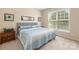 Bedroom featuring neutral walls, matching nightstands, and a bright window at 128 Sugar Thyme Ln, Mooresville, NC 28115
