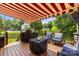 Outdoor deck featuring awning, seating, grill, and view of landscaped backyard at 128 Sugar Thyme Ln, Mooresville, NC 28115