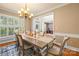 Bright dining room with large windows, stylish chandelier, hardwood floors, and open view to entryway at 128 Sugar Thyme Ln, Mooresville, NC 28115