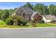 Beautiful two-story brick home with lush landscaping and a side-entry garage, offering a suburban charm at 128 Sugar Thyme Ln, Mooresville, NC 28115
