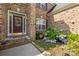 Inviting front entry with decorative glass door, sidelight window, and charming landscaping around the porch at 128 Sugar Thyme Ln, Mooresville, NC 28115