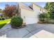 This home features a two car garage with driveway and mature landscaping at 128 Sugar Thyme Ln, Mooresville, NC 28115