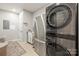 Laundry room features modern washer/dryer, stainless steel refrigerator, and tile floors at 128 Sugar Thyme Ln, Mooresville, NC 28115