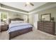 Spacious primary bedroom with tray ceiling, carpet, and neutral tones at 128 Sugar Thyme Ln, Mooresville, NC 28115