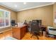 Home office with a large wooden desk, rolling chairs, and natural light from a large window at 128 Sugar Thyme Ln, Mooresville, NC 28115
