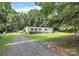 Home featuring a gravel driveway, lush lawn, and mature trees for privacy and a tranquil setting at 1310 Glasscock Rd, Rock Hill, SC 29730