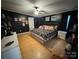 Bedroom featuring a large bed, hardwood flooring, ceiling fan, and stylish decor at 13211 Asbury Chapel Rd, Huntersville, NC 28078