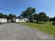 Single-story home featuring a gravel driveway, a spacious front yard, and a storage shed at 13211 Asbury Chapel Rd, Huntersville, NC 28078