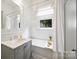 Traditional white bathroom features wainscoting, tub, shower, neutral vanity, and bright window at 1417 The Plz, Charlotte, NC 28205